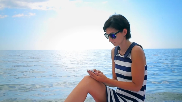 Young Woman Using Cellphone On Sea Background