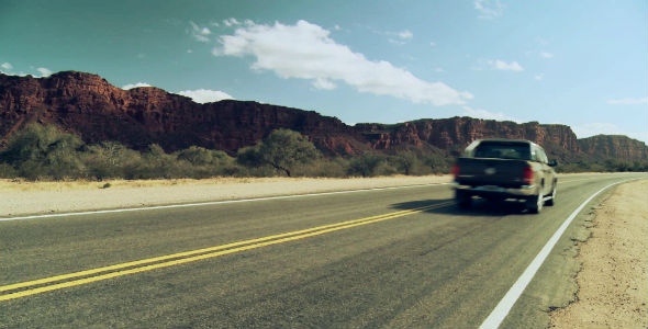 Pickup Truck on a Road in an Arid Landscape.