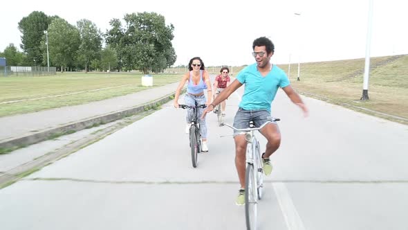 Three Young Adults Having Fun Cycling And Taking Selfies