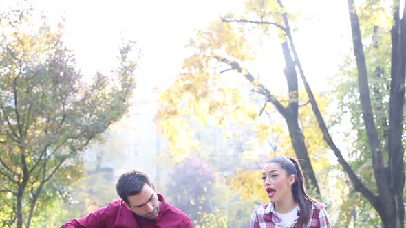 Man Playing Guitar And Singing With Women While Sitting On Bench In Park 3