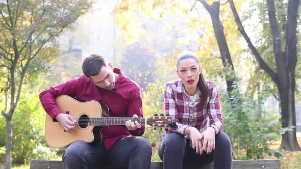 Man Playing Guitar While Woman Singing 1