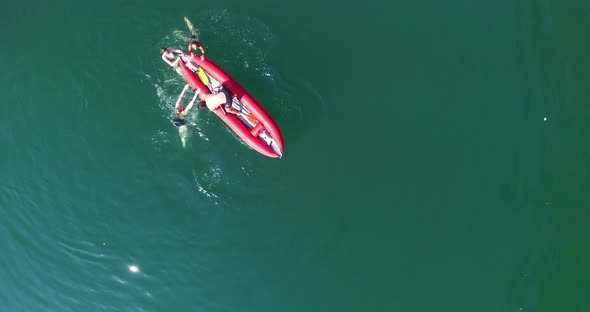 Female Friends Shaking Canoe While Their Male Friend Trying To Jump From Canoe