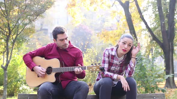 Man Playing Guitar While Woman Singing 5