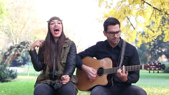 Brunette Woman Singing While Handsome Man Playing Guitar 3
