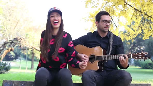 Young Brunette Woman Singing While Handsome Man Playing Guitar