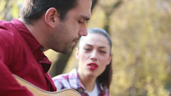 Brunette Woman Singing While Man Playing Guitar 2