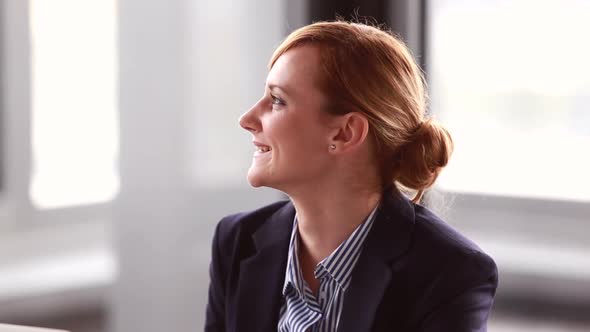 Young Businesswoman Listening And Nodding During Corporate Presentation