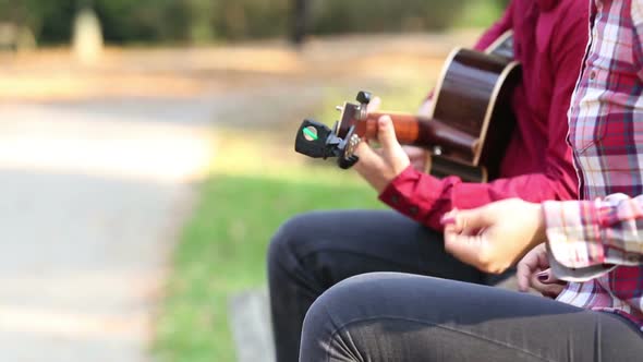 Young Couple Playing Guitar And Singing In Park 4