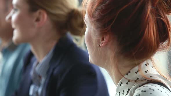 Close Up Of Red Hair Woman Talking During A Meeting, Colleagues In Background