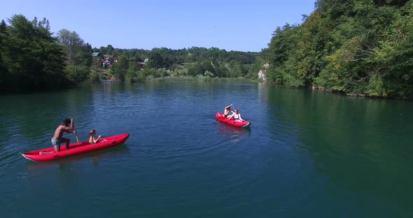 Four Young Friends Paddling Canoe And Splashing Each Other With Water 4