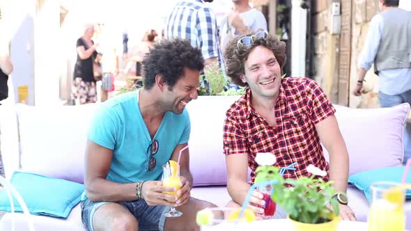 Two Male Friends Drinking Cocktails On Terrace Cafe In Summer 2