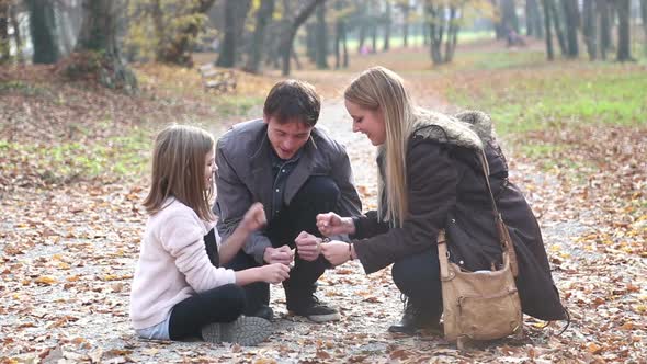 Parents Having Fun With Daughter Playing Games In The Park