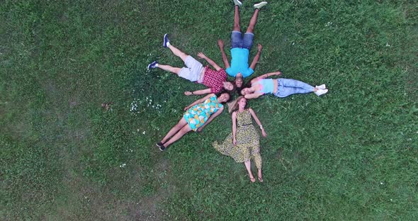 Young Happy Friends Forming A Star Shape Lying In Grass 2