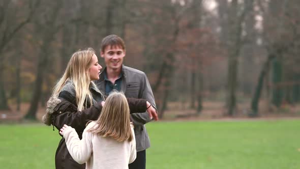 Parents Playing With Daughter In Park