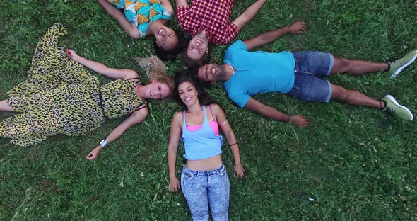 View From Above Of Friends Forming A Star Shape Lying In Grass 2