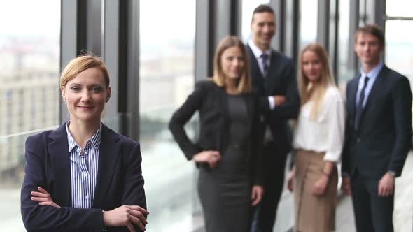 Portrait Of Blonde Businesswoman Smiling, Colleagues In Background 1