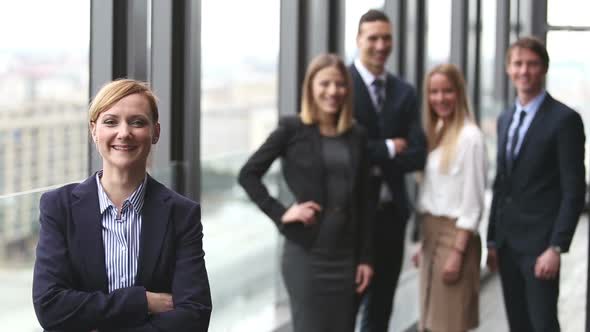 Portrait Of Blonde Businesswoman Smiling, Colleagues In Background 2