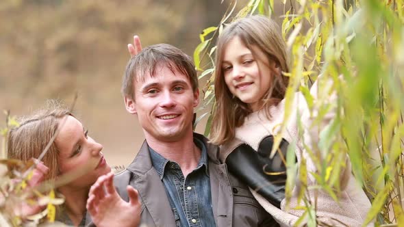 Portrait Of Family Smiling And Waving In Park 1