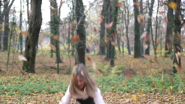 Girl Having Fun Throwing Leaves And Jumping In The Park