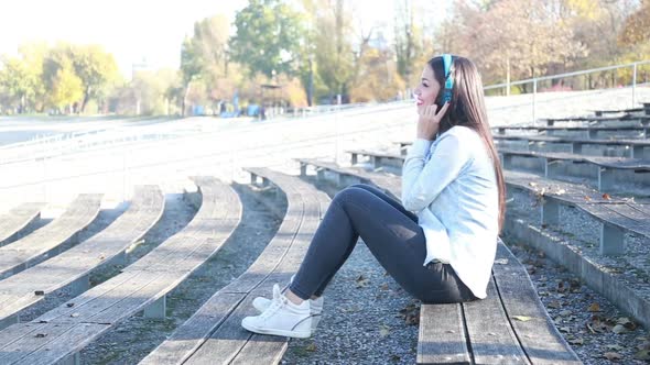 Attractive Brunette Woman Listening To Music With Headphones At Park 2