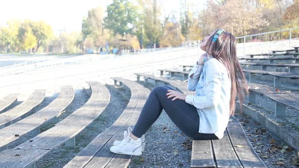 Attractive Brunette Woman Listening To Music With Headphones At Park 3