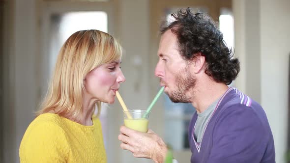 Couple Drinking Smoothie From Same Drinking Glass