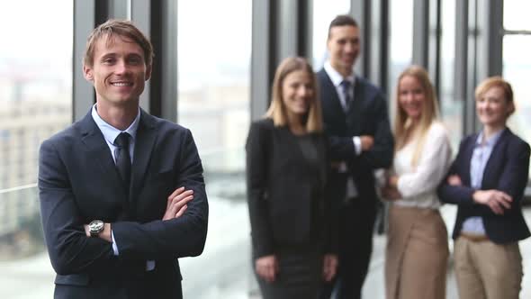 Portrait Of Handsome Businessman Smiling, Colleagues In Background 2