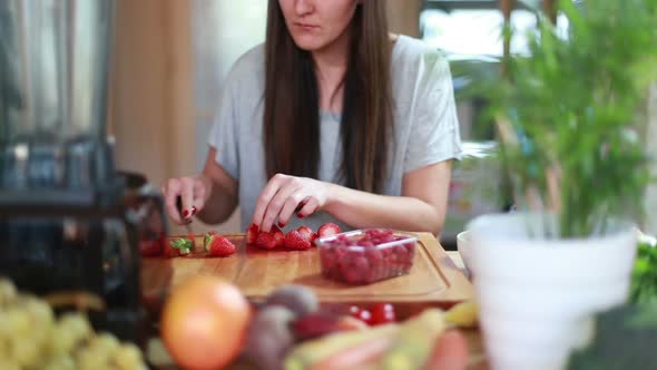 Young Woman Cutting Strawberries 1
