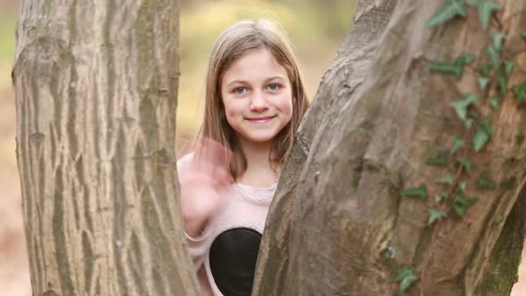 Girl Standing By The Tree And Waving