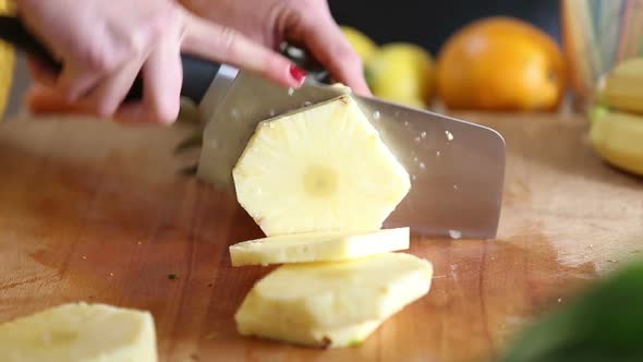 View Of Woman Hands Cutting Pineapple Into Slices