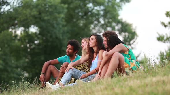 Group Of Friends Sitting On Grass Having A Good Time