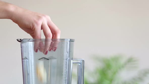 Hand Putting Pieces Of Orange In Blender