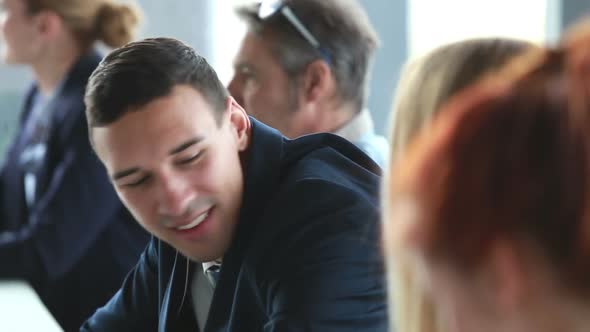 Handsome Businessman Talking With Female Colleagues At Conference Table