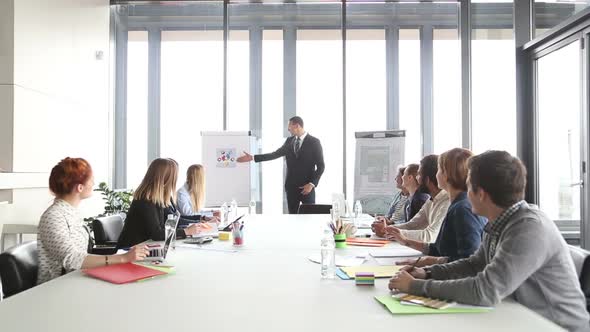 Handsome Director Pointing At Flipchart During A Meeting 1