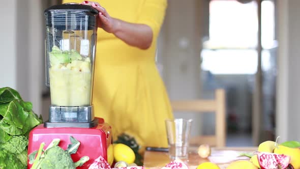 Woman Blending Pineapple And Avocado