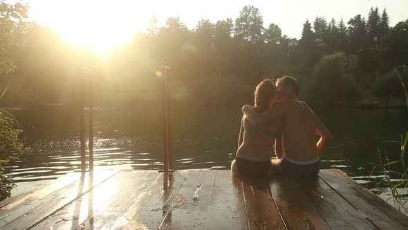 Romantic Couple Kissing While Sitting By The River At Sunset 2