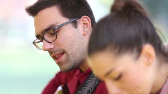 Couple Playing Guitar And Singing While Sitting On A Tree 3