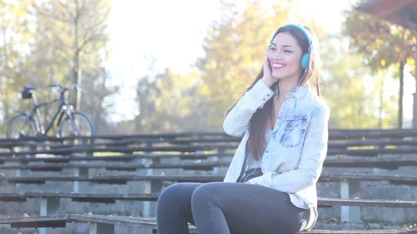 Beautiful Woman Listening To Music With Headphones At The Park 1
