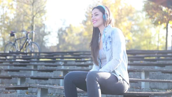 Beautiful Woman Listening To Music With Headphones At The Park 2