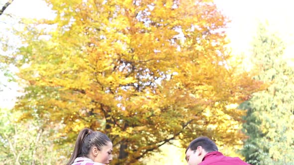 Couple Sitting On Park Bench, Man Playing Guitar While Woman Singing 2