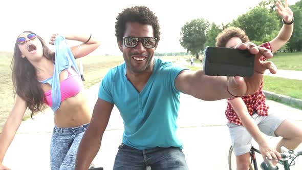 Slow Motion Of Three Young Adults On Bikes Taking Selfies With Phone, Graded