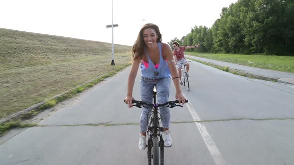 Beautiful Woman Sending Kisses While Cycling With Friends 1