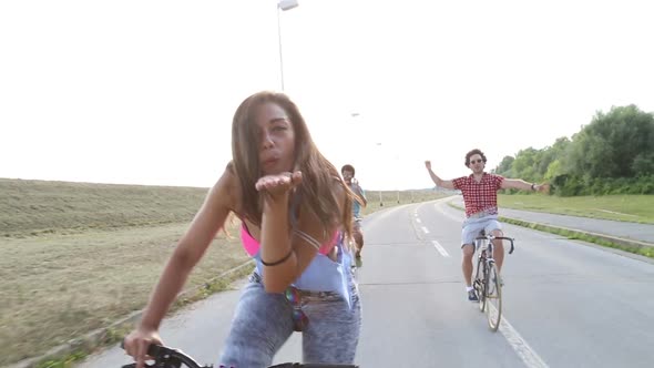 Beautiful Woman Sending Kisses While Cycling With Friends 4