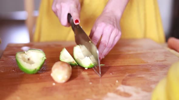 Woman Hands Cutting Avocado On Slices