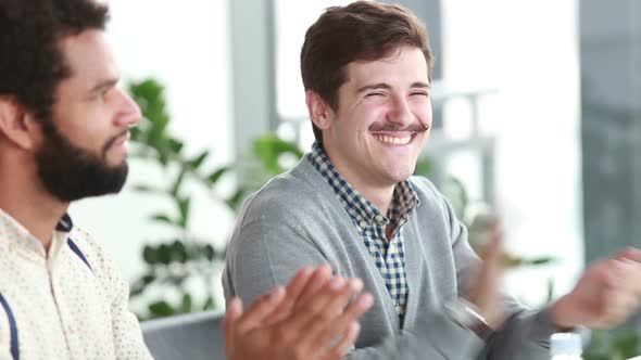 Male Colleagues Applauding During Presentation In Conference Room 1