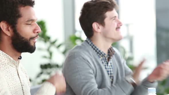 Male Colleagues Applauding During Presentation In Conference Room 2