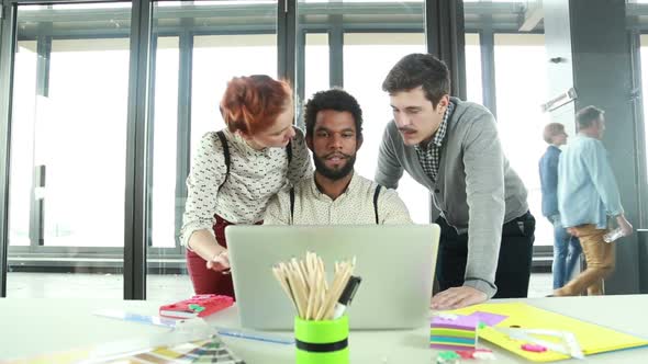 Male Creative Executive Discussing New Ideas On Laptop With Colleagues 1