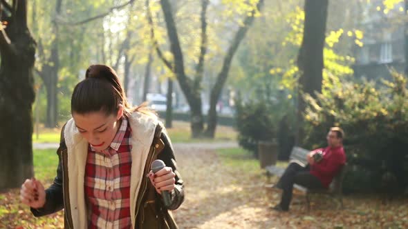 Beautiful Woman Singing In Park While Man Playing Guitar In Background 4