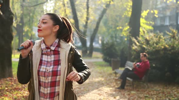 Beautiful Woman Singing In Park While Man Playing Guitar In Background 6