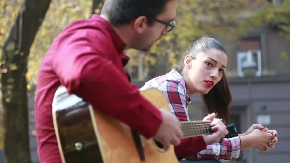 Beautiful Woman Singing While Handsome Man Playing Guitar 1